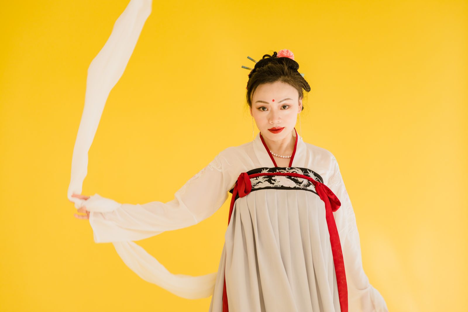 Woman wearing Hanfu with traditional crossed collar, portrait against yellow background